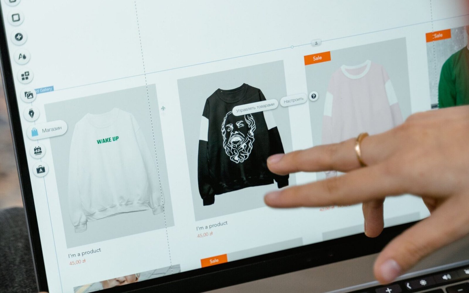 Close-up of hands interacting with a shopping website on a laptop screen indoors.